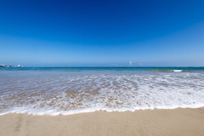 On the beach, white sand, sun loungers, beach umbrellas