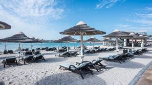 Privatstrand, weißer Sandstrand, Liegestühle, Sonnenschirme