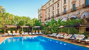 Una piscina al aire libre, sombrillas, tumbonas