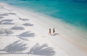 On the beach, white sand, sun loungers, beach umbrellas