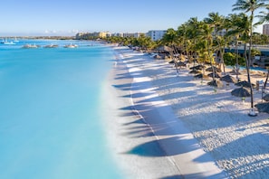On the beach, white sand, sun loungers, beach umbrellas