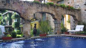 Una piscina al aire libre, sombrillas, tumbonas