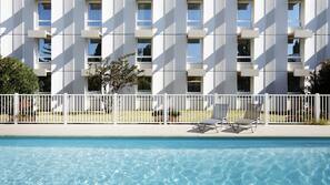 Una piscina al aire libre, tumbonas