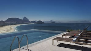 Una piscina al aire libre, tumbonas