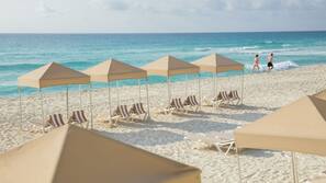 On the beach, white sand, sun loungers, beach umbrellas
