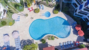 Een buitenzwembad, parasols voor strand/zwembad
