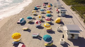 Am Strand, weißer Sandstrand, Liegestühle, Sonnenschirme