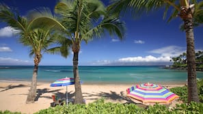On the beach, white sand, sun loungers, beach umbrellas