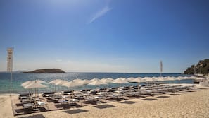 On the beach, white sand, beach cabanas, sun-loungers