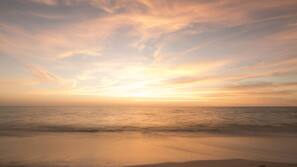 On the beach, white sand, beach cabanas, sun loungers