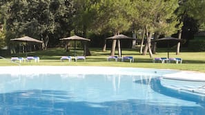 Una piscina al aire libre, socorrista en las instalaciones