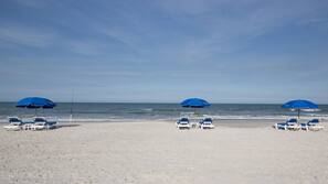On the beach, white sand, sun loungers, beach umbrellas