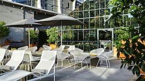 Una piscina al aire libre, sombrillas, tumbonas