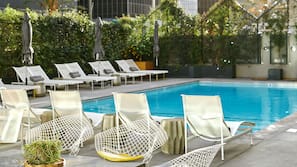Una piscina al aire libre, sombrillas, tumbonas