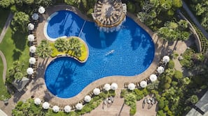 Una piscina al aire libre de temporada, sombrillas