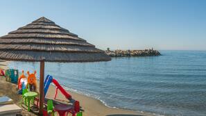Sulla spiaggia, lettini da mare, ombrelloni, teli da spiaggia