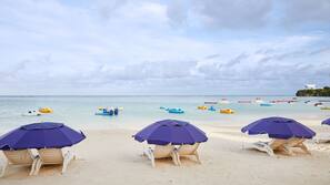 On the beach, white sand, sun loungers, beach umbrellas