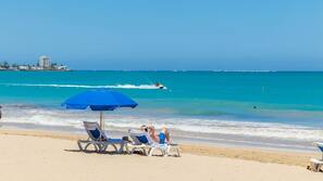 On the beach, white sand, sun-loungers, beach towels