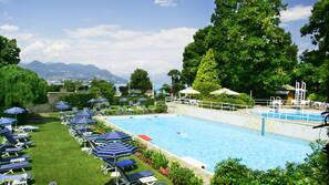 Una piscina cubierta, una piscina al aire libre de temporada, sombrillas