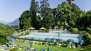 Una piscina cubierta, una piscina al aire libre de temporada, sombrillas