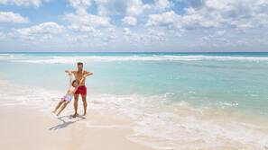 On the beach, white sand, sun loungers, beach umbrellas