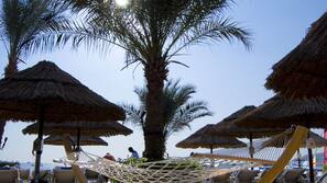 On the beach, sun-loungers, beach umbrellas, beach towels