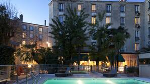 Una piscina al aire libre, sombrillas, tumbonas