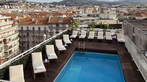 Una piscina al aire libre, tumbonas