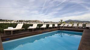 Una piscina al aire libre, tumbonas