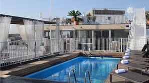 Una piscina al aire libre, tumbonas