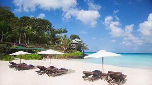 On the beach, white sand, sun loungers, beach umbrellas