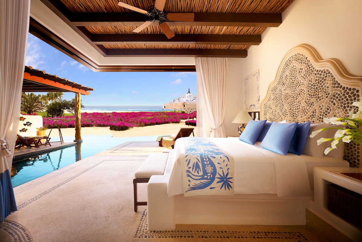 beautiful white homes with pink roofs and large white rock formations behind on the beach in cabo san lucas, one of the Best Mexican Beach Towns