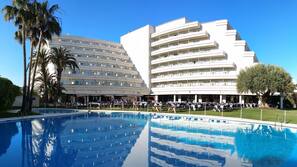 Una piscina al aire libre de temporada, sombrillas, tumbonas