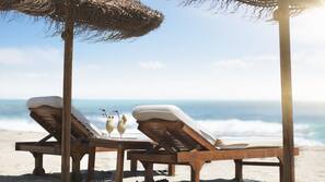 On the beach, black sand, beach towels, 2 beach bars