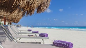 On the beach, white sand, beach towels, beach volleyball
