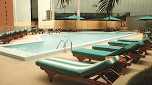 Una piscina al aire libre de temporada, sombrillas
