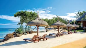 On the beach, white sand, sun-loungers, beach umbrellas