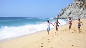 Na praia, espreguiçadeiras, guarda-sóis, toalhas de praia