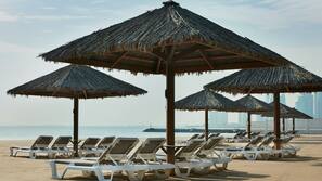 Aan een privéstrand, parasols, strandlakens, yoga