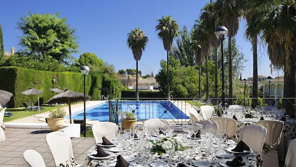 Una piscina al aire libre, sombrillas