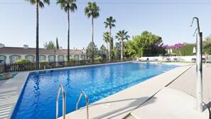 Una piscina al aire libre, sombrillas