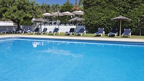 Una piscina al aire libre, sombrillas