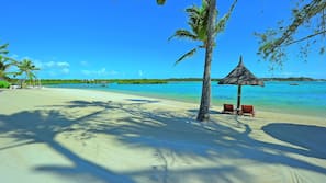 On the beach, white sand, sun loungers, beach umbrellas