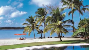 On the beach, white sand, sun loungers, beach umbrellas