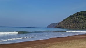On the beach, black sand, sun loungers, beach towels