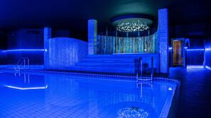 Una piscina cubierta, tumbonas