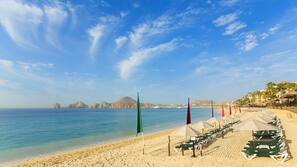 On the beach, white sand, sun loungers, beach umbrellas