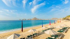 On the beach, white sand, sun loungers, beach umbrellas