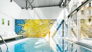 Una piscina cubierta, tumbonas