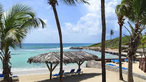 On the beach, white sand, sun loungers, beach bar